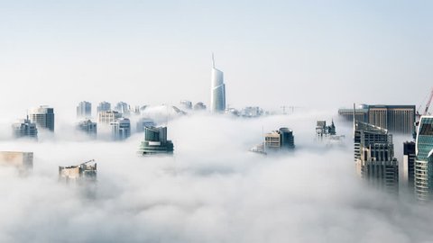 Cinemagraph of skyscrapers above the clouds in Hong Kong with clouds rolling through city in