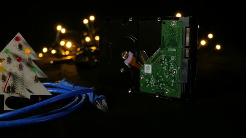 LED christmas tree with hard drive in background and LAN cable around it. Camera moving sidewards.