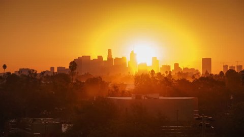 Sunrise over city, closeup on modern downtown Los Angeles skyline buildings silhouettes. 4K UHD timelapse.
