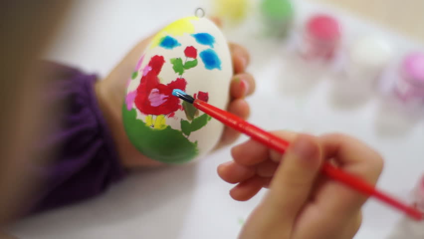 Learning to Draw. Child decorates Easter egg