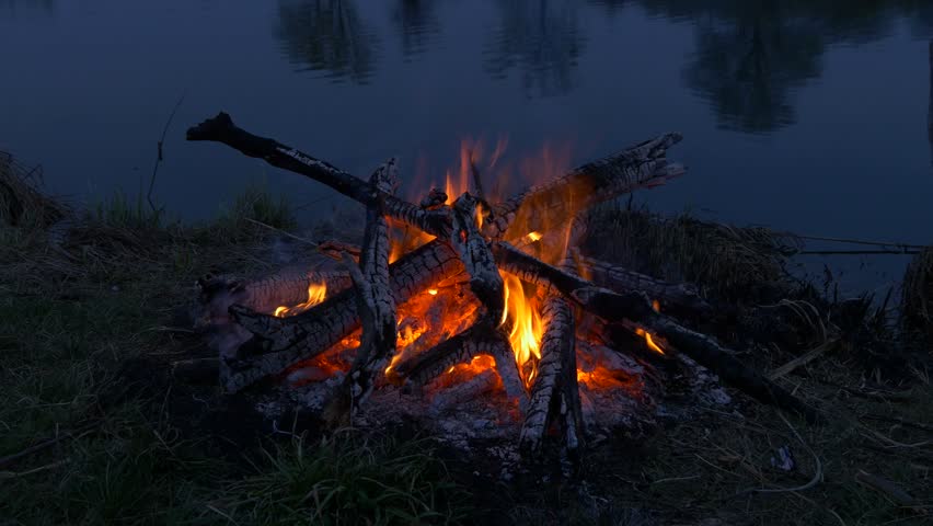 Campfire near water. River evening time Royalty-Free Stock Footage #32358982