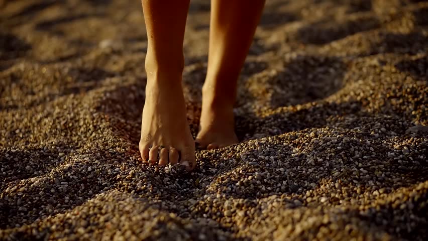 Barefoot woman is walking over a coarse sand in evening time, sun is shining at an angle | Shutterstock HD Video #32360158