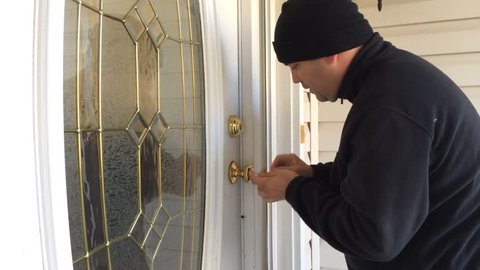 Burglar breaking into home while owners at work