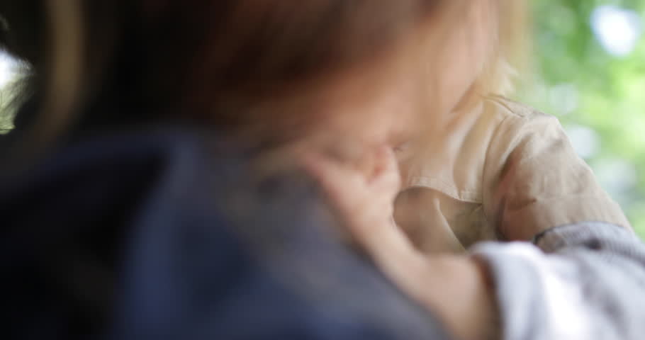 Child kissing mother in park