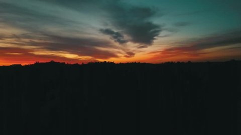 Aerial drone footage of a silhouetted skyline with brilliant sunset colors.