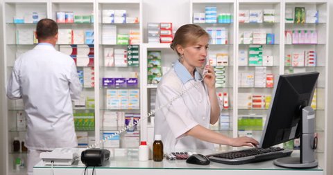 Happy Pharmacist Woman Give Positive Response Talking Landline Phone in Pharmacy