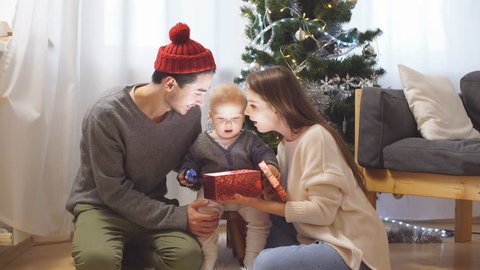 Young family opens a Christmas gift.