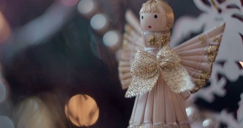 Close-up of tiny toy of angel with golden bow for decorating Christmas tree. 