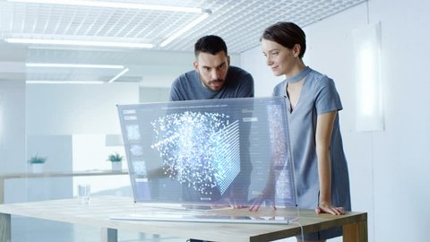 In the Near Future Male and Female Computer Engineers Talk While Working on the Transparent Display Computer. Screen Shows Interactive Neural Network, Artificial Intelligence Project. 4K UHD.