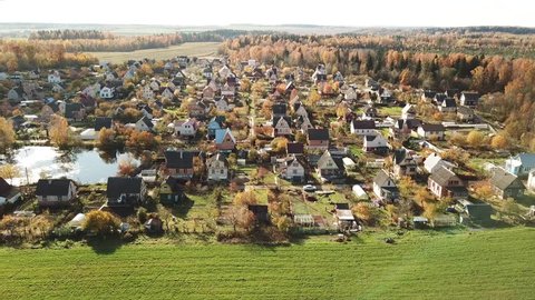 AERIAL SHOT: Beautiful small village in the autumn forest.