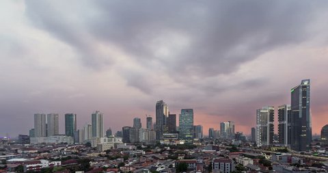 Sunset time lapse, as a day to night video, over Jakarta skyline business district in Indonesia capital city. Jakarta is Indonesia capital city and the largest city in Southeast Asia. 