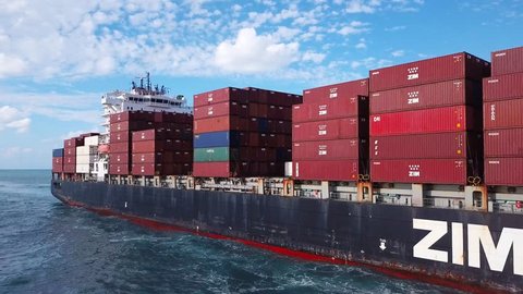 Mediterranean sea - October 25, 2017: Low angle view of a Large ZIM container ship at sea, loaded with various container brands - Aerial footage