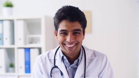 medicine, healthcare and people concept - portrait of happy smiling young indian male doctor