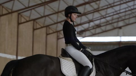 Dressage athlete riding horse in training facility for equestrianの動画素材