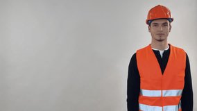 Portrait professional worker wearing uniform orange hard hat and safety vest showing on copy space. Candid cheerful man pointing on three item presentation - Powered by Shutterstock - Get 15% off with code: PIKWIZARD15