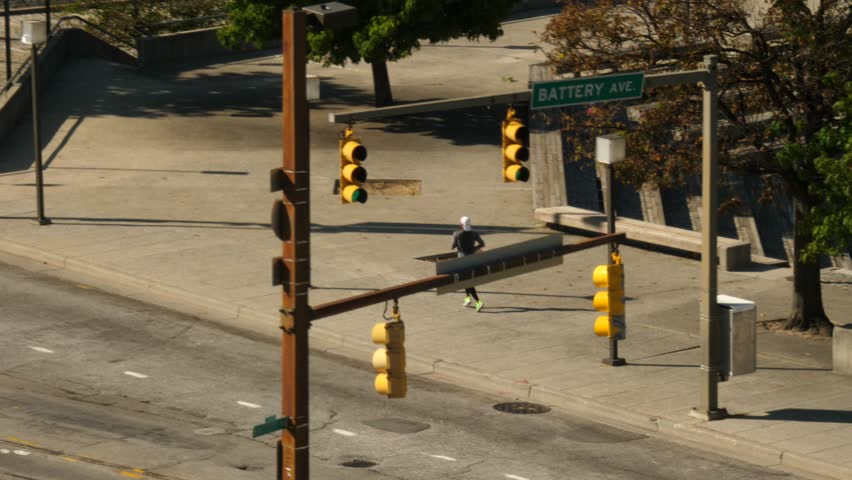 Man running down the street Baltimore Harbor with Stop Lights