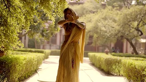 European girl tourist in the national Indian clothes Sari dancing in the Park city Vrindavan. 