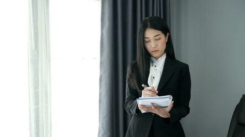 business woman standing write note thinking in intuitive way on office