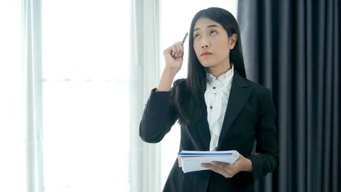 business woman standing write note thinking in intuitive way on office