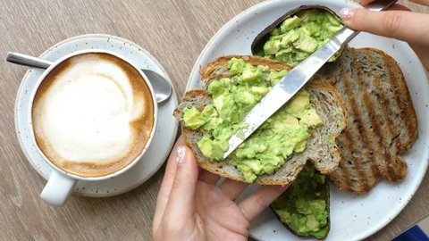 Top View Of Healthy Breakfast With Avocado Toast And Coffee In Cafe. Closeup. 4K. 
