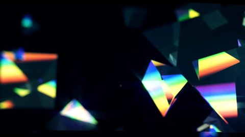 Rainbow triangle prisms float close up on black background 库存视频