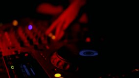 lifestyle, technologies, emotions, people, video, movie, 4K concept - Girl DJ dancing develop her hair behind multicolored lights. Silhouette DJ equipment, hands, face close-up. Slow motion, 4K