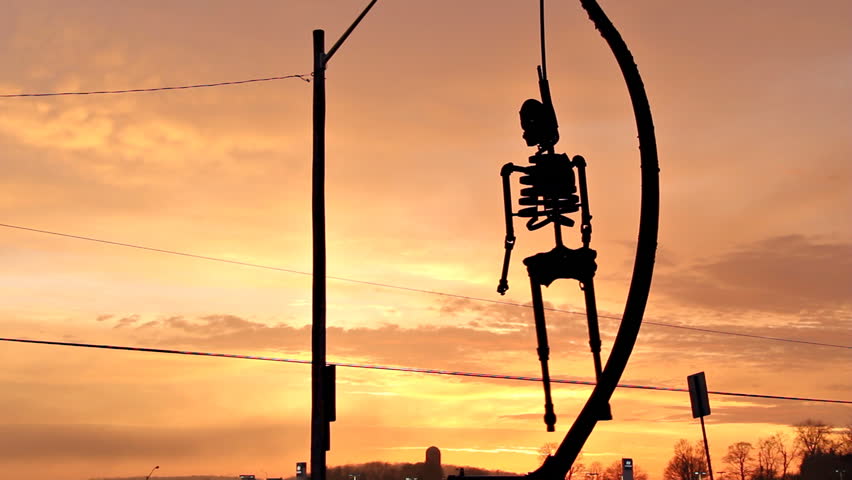 Hanging Skeleton Sunset 2. Rusted metal skeleton silhouette hanging from a noose
