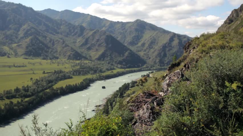 male traveler reached the top of the mountain overlooking the river