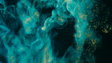 Ink in water. Turquoise with gold glitter paint reacting in water creating abstract cloud formations.Can be used as transitions,added to modern projects,art backgrounds, anything with creative twist.