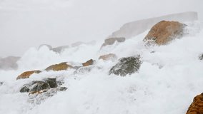 Foaming water crashing on the rocks at the base of Niagara Falls. Slow motion 180 fps video