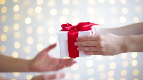 close up of female hands giving a Christmas gift to boyfriend