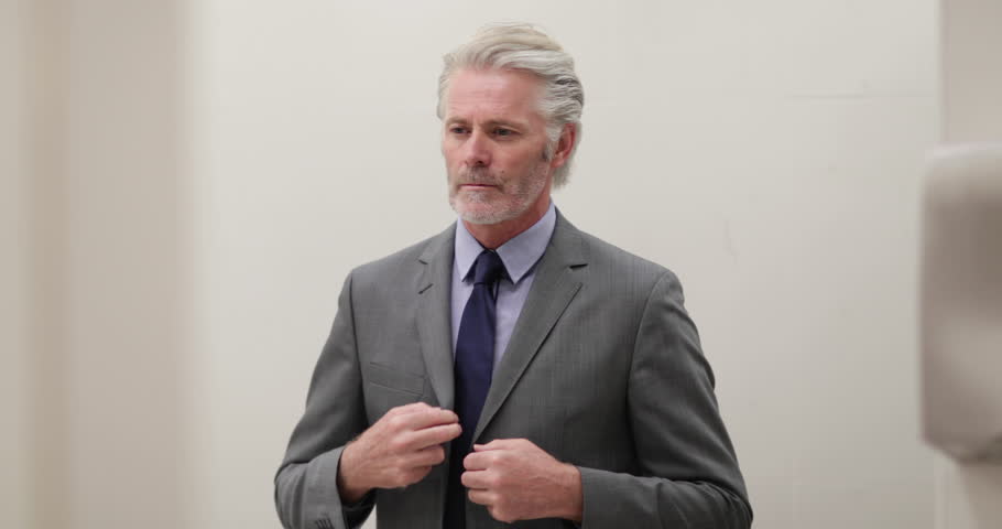 Businessman looking in a mirror preparing for business meeting