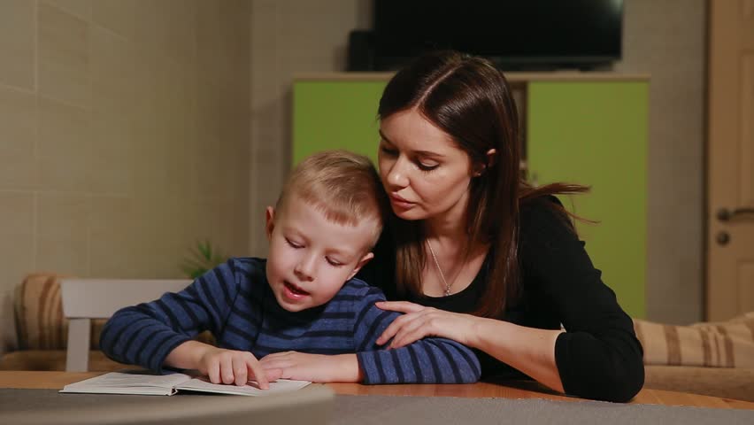 Mother and son sitting in the kitchen of his house and learning to read book. | Shutterstock HD Video #32483635