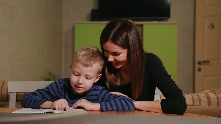 Mother and son sitting in the kitchen of his house and learning to read book. | Shutterstock HD Video #32483698