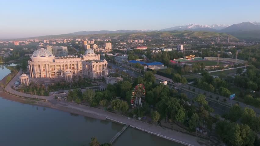 Aerial panoramic morning shot of the Dushanbe city and main stadium with mountains on background