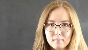 Mongolian girl doing funny face on camera on dark background