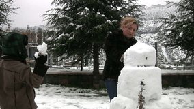 Mother and son with snowman