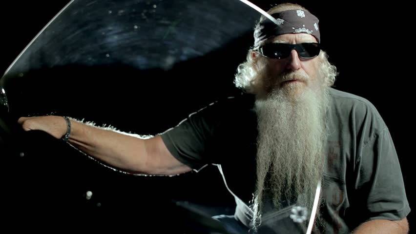 Mature Biker sitting on his motorcycle. Dolly shot, moving from left to right.