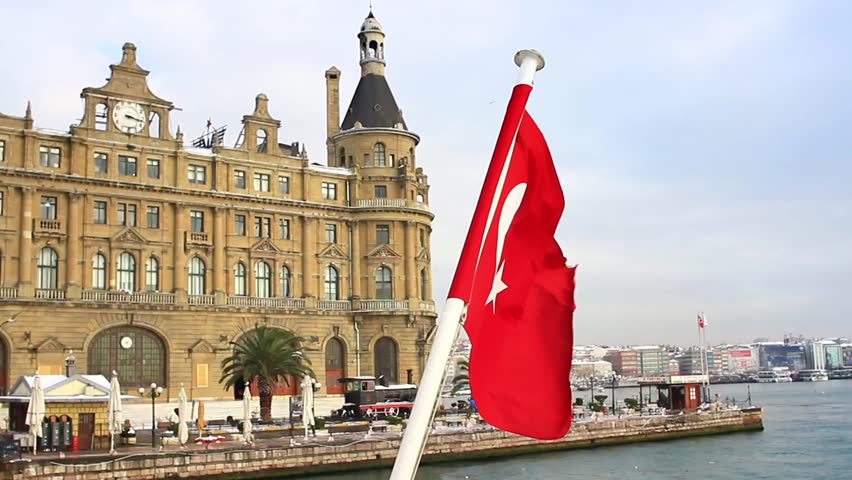 Haydarpasa Station Building with a Turkish Flag waving on ship deck.
