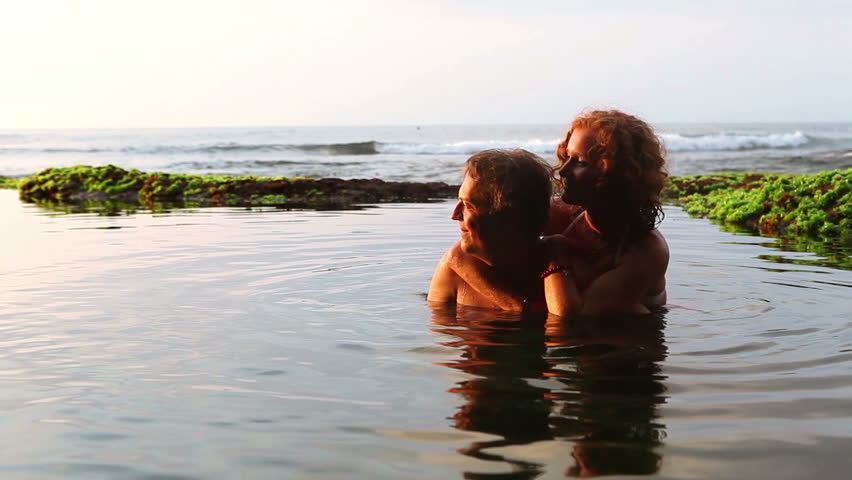 Loving couple hugging in Bali lagoon while summer vacation
