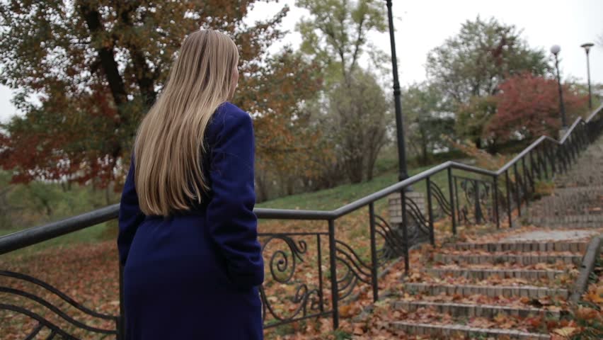 Stunning woman climbing staircase in autumn park