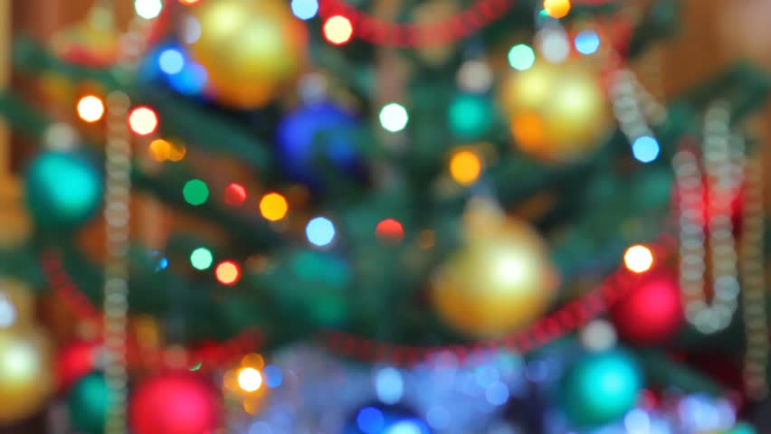 Christmas pine tree defocused. Colorful garland lights are sparkling on the