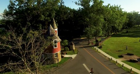 Aerial view of Davis & Elkins College Gate House with camera orbiting and then pulling away just before sunset.