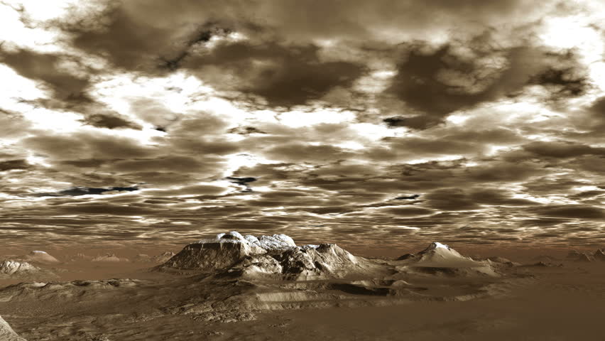 Low Thick Clouds over the Mountains. Low Dense Clouds fly over a deserted mountain landscape. The tops are covered with snow. In the lowlands a thick brown mist. Landscape lit by a bright light.