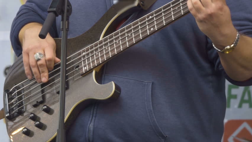 Guitarists hands playing song on electric guitar. Man playing electric guitar on stage at a rock concert