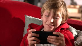 Young boy playing on a digital tablet in the living room