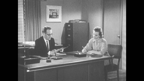 1950s: Man dictates to secretary at office desk. Secretary stands to leave. Secretary returns to desk and speaks with man. Man and woman speak.