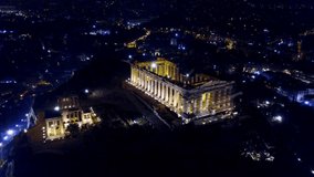 Aerial drone bird's eye night video of iconic Acropolis hill and the Parthenon, Athens historic center, Attica, Greece