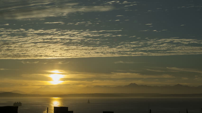 Sunset over Seattle Bay with the sun setting behind Olympic National Park and