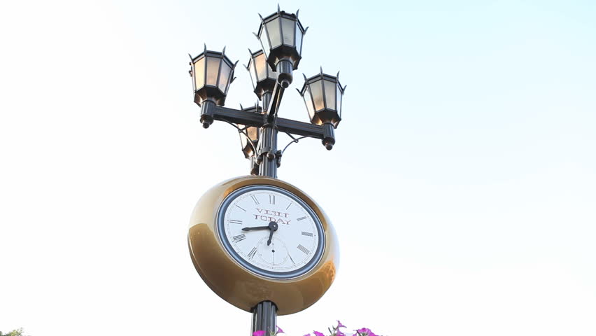 Historic street clock with lantern and time running back